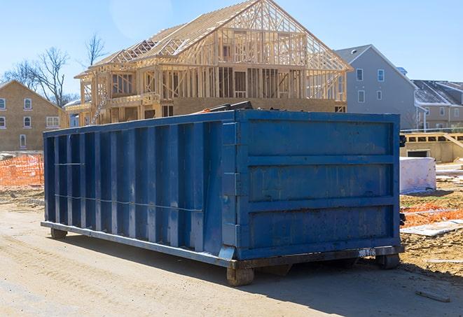 a garbage truck loading residential dumpsters in the early morning